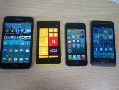 Il dispositivo BlackBerry L-Series posa accanto ai seguenti smartphone: iPhone, Lumia e Note!!